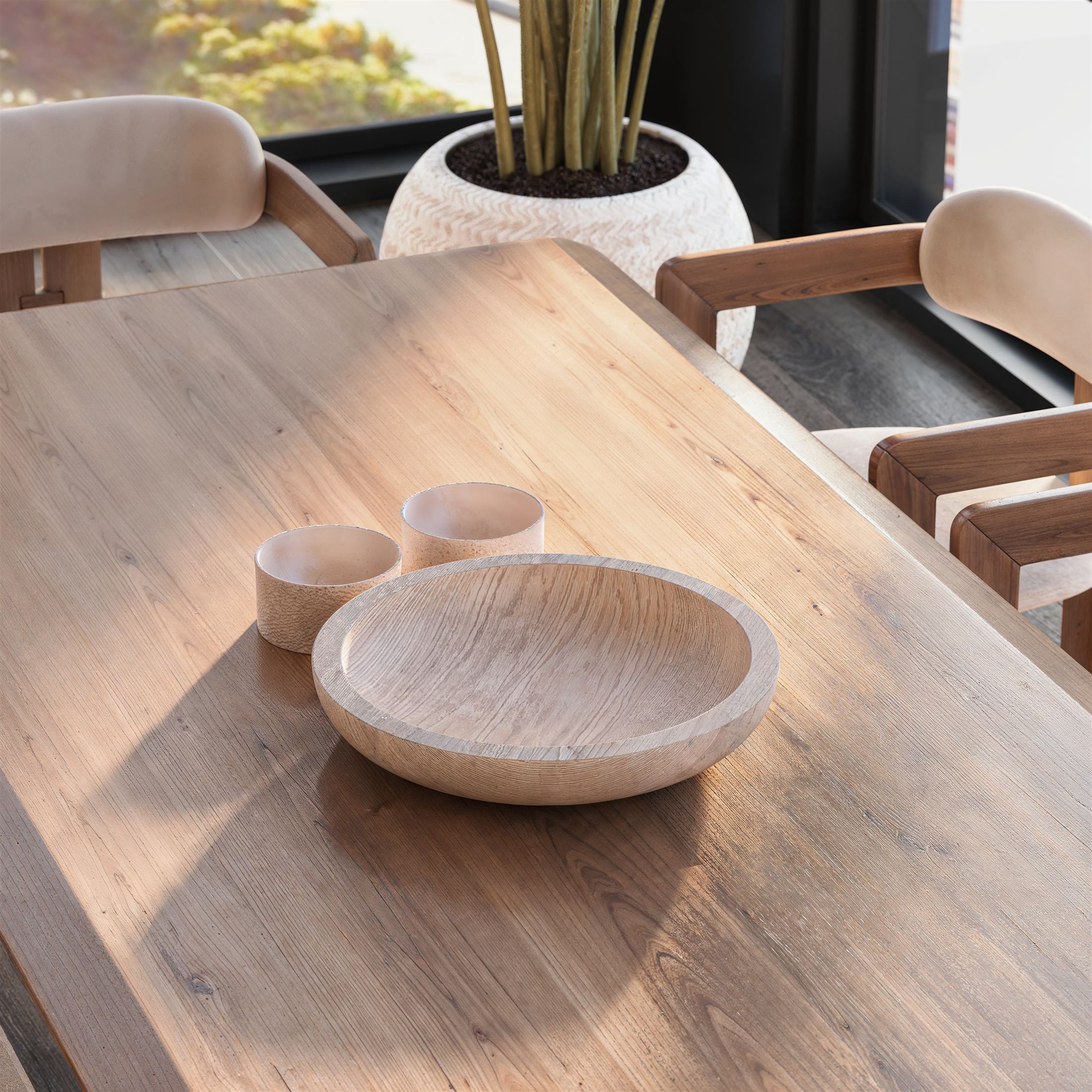 Sunlight across an oak dining table with turned wooden bowls